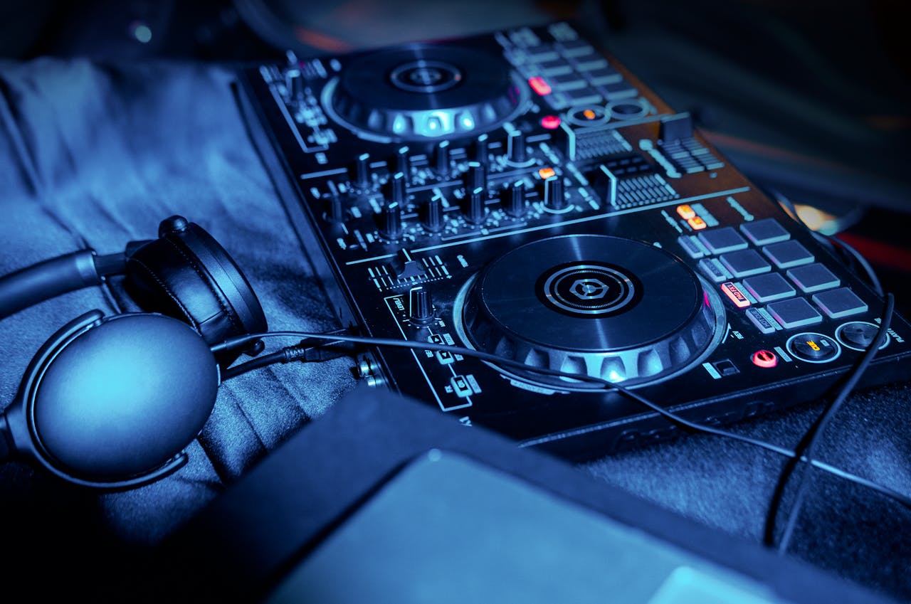 Close-up shot of DJ mixer and headphones under vibrant blue light. Ideal for music technology themes.