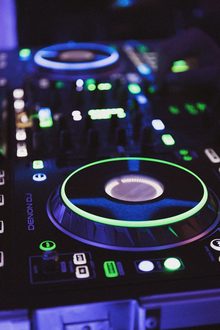 Close-up of a DJ mixer with colorful glowing lights, creating a vivid nightlife ambiance.