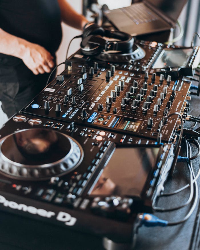 Professional DJ operating modern mixing equipment during an indoor event.